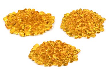 Beyaz zemin üzerinde izole edilmiş bir grup sarı kapsül. 