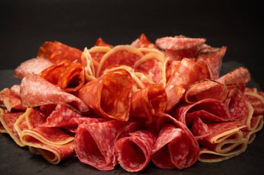 Tahtada farklı et parçaları var. Siyah bir arkaplanda.