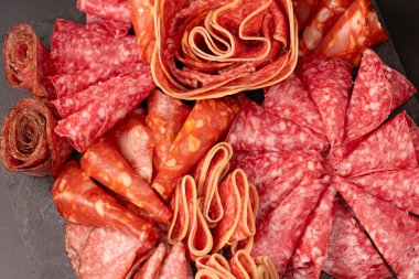 Tahtada farklı et parçaları var. Siyah bir arkaplanda.