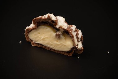 Siyah arka planda hindistan cevizi kremalı profiterol.. 