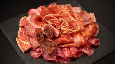 Tahtada farklı et parçaları var. Siyah bir arkaplanda.