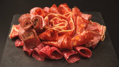 Tahtada farklı et parçaları var. Siyah bir arkaplanda.