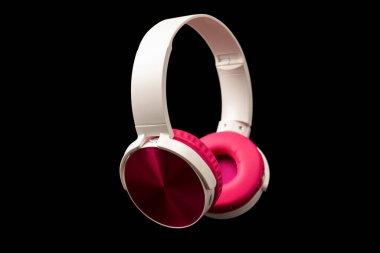 Siyah arkaplanda pembe ve beyaz kulaklıklar var.. 