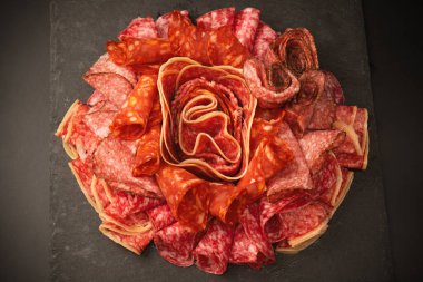 Tahtada farklı et parçaları var. Siyah bir arkaplanda.