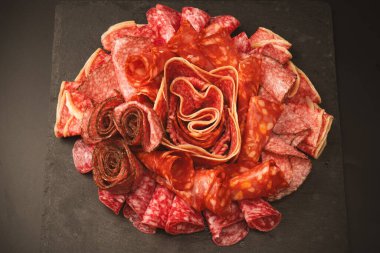 Tahtada farklı et parçaları var. Siyah bir arkaplanda.