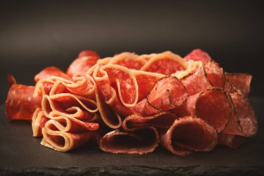 Tahtada farklı et parçaları var. Siyah bir arkaplanda.