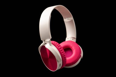 Siyah arkaplanda pembe ve beyaz kulaklıklar var.. 