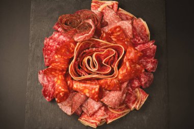 Tahtada farklı et parçaları var. Siyah bir arkaplanda.