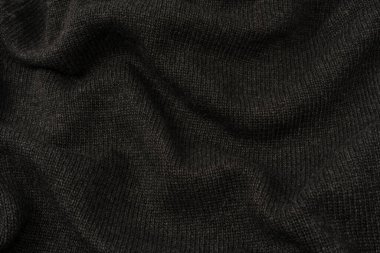 Arka plan olarak koyu gri süveter dokusu. Örgü desenli. Üst görünüm. 