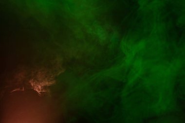 Siyah arka planda yeşil ve pembe buhar. Boşluğu kopyala.