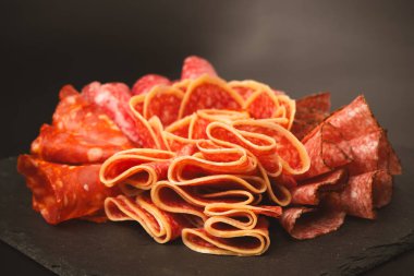 Tahtada farklı et parçaları var. Siyah bir arkaplanda.