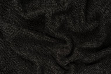 Arka plan olarak koyu gri süveter dokusu. Örgü desenli. Üst görünüm. 