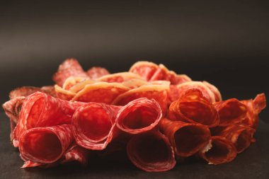 Tahtada farklı et parçaları var. Siyah bir arkaplanda.