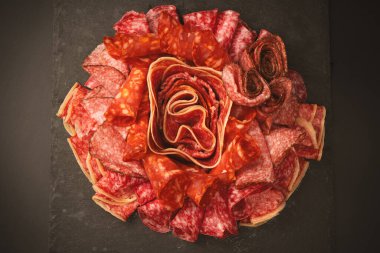 Tahtada farklı et parçaları var. Siyah bir arkaplanda.