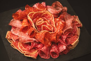 Tahtada farklı et parçaları var. Siyah bir arkaplanda.