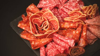 Tahtada farklı et parçaları var. Siyah bir arkaplanda.