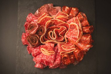 Tahtada farklı et parçaları var. Siyah bir arkaplanda.