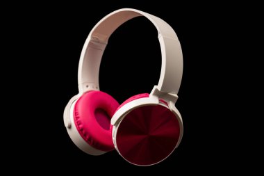 Siyah arkaplanda pembe ve beyaz kulaklıklar var.. 