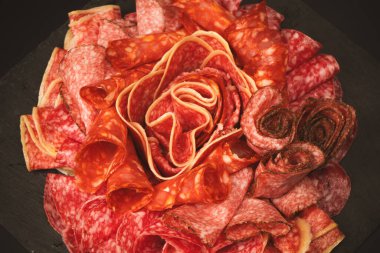 Tahtada farklı et parçaları var. Siyah bir arkaplanda.