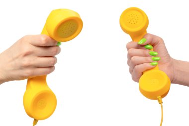 Beyaz arka planda izole edilmiş yeşil tırnaklı kadın eli sarı cep telefonu. Boşluğu kopyala.