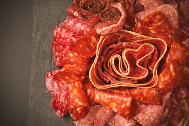 Tahtada farklı et parçaları var. Siyah bir arkaplanda.