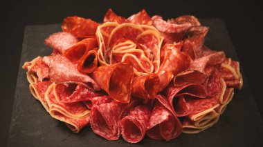 Tahtada farklı et parçaları var. Siyah bir arkaplanda.