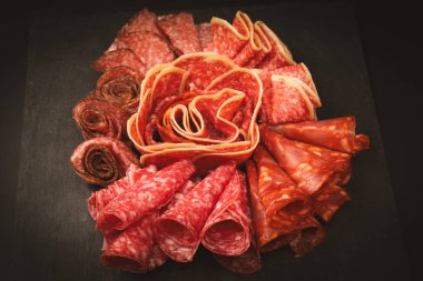 Tahtada farklı et parçaları var. Siyah bir arkaplanda.