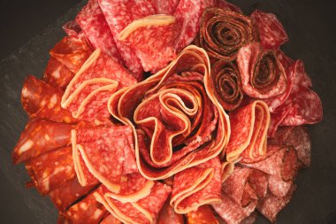 Tahtada farklı et parçaları var. Siyah bir arkaplanda.