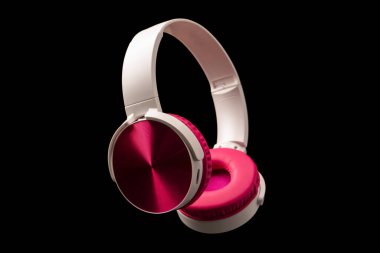 Siyah arkaplanda pembe ve beyaz kulaklıklar var.. 