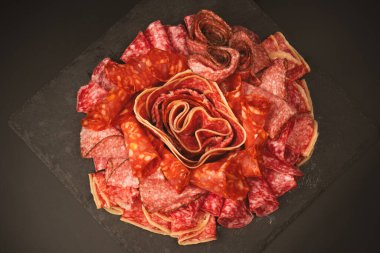 Tahtada farklı et parçaları var. Siyah bir arkaplanda.