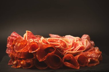 Tahtada farklı et parçaları var. Siyah bir arkaplanda.