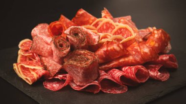 Tahtada farklı et parçaları var. Siyah bir arkaplanda.