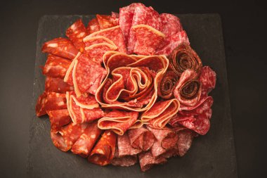 Tahtada farklı et parçaları var. Siyah bir arkaplanda.