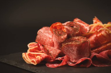 Tahtada farklı et parçaları var. Siyah bir arkaplanda.