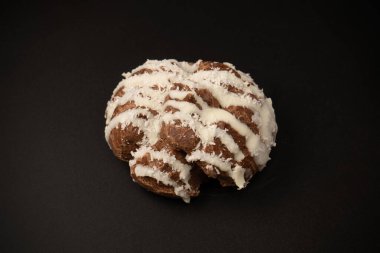 Siyah arka planda hindistan cevizi kremalı profiterol.. 