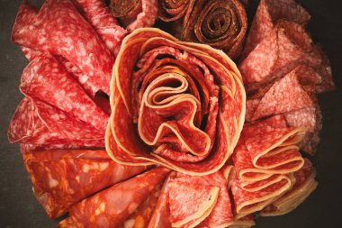 Tahtada farklı et parçaları var. Siyah bir arkaplanda.