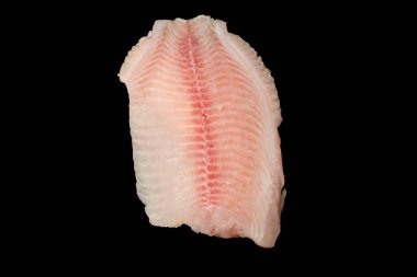 Siyah arkaplanda taze tilapia filetosu, üst görünüm. 