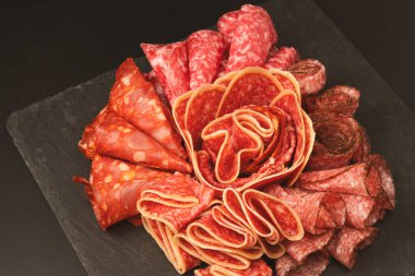 Tahtada farklı et parçaları var. Siyah bir arkaplanda.