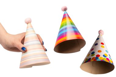 Beyaz arka planda izole edilmiş kadınların ellerinde renkli bir doğum günü şapkası..