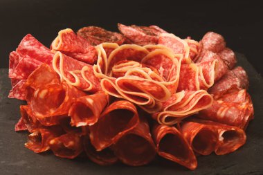 Tahtada farklı et parçaları var. Siyah bir arkaplanda.