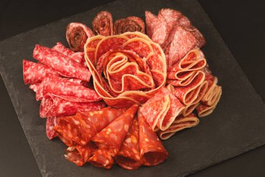 Tahtada farklı et parçaları var. Siyah bir arkaplanda.