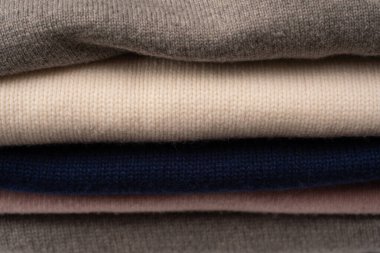 Beyaz arka planda izole edilmiş bir grup kalın kazak. Beyaz arkaplanda katlanmış süveter yığını.