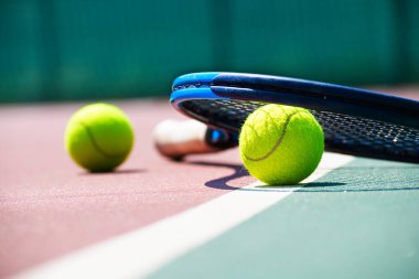 Tennis racquet and ball lying on the court. Healthy lifestyle concept