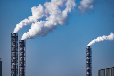 Mavi gökyüzü arka planında bir yığın kömür santrali. Metin için yer