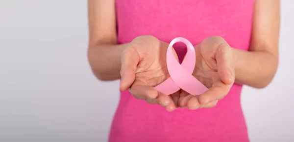 白种人女模手握乳腺癌意识粉红丝带 图库照片