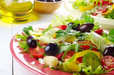 Sağlıklı sebze ev yapımı lezzetli taze organik salata beyaz masada.
