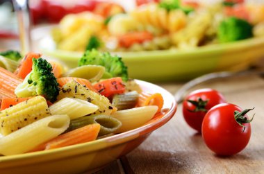 makarna penne brokoli havuç Mısır ve mutfak masasının üzerinde domates salatası