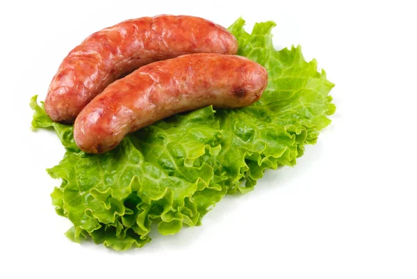 stock image Roasted pork sausages with lettuce on white background