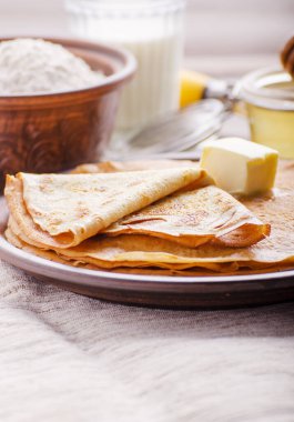 Tereyağı un süt ve bal Ahşap mutfak masasında seramik tabak ile Fransız krep