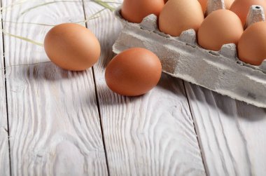 Eko Dostu kağıt karton beyaz mutfak ahşap masa üzerinde ham organik kahverengi tavuk yumurta